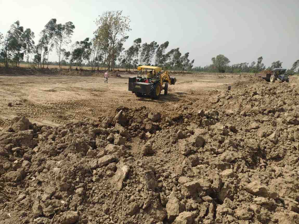 धामपुर, बिजनौर में रात में खेतों में मिट्टी खनन करती जेसीबी मशीन।