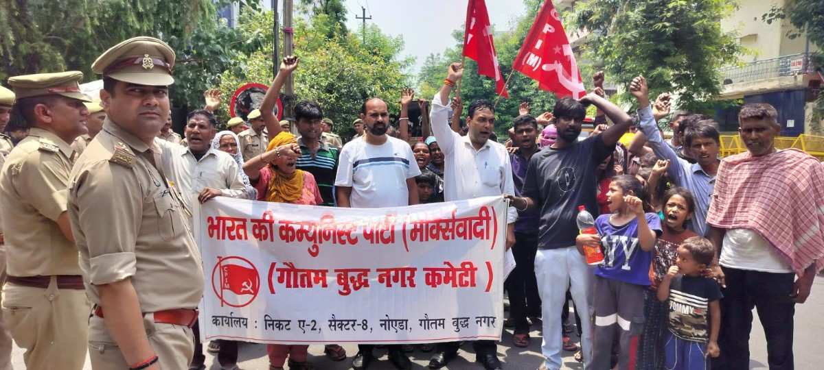 नोएडा के सेक्टर-6 में नोएडा प्राधिकरण कार्यालय के बाहर CPI(M) के बैनर तले प्रदर्शन करते झुग्गी वासी।