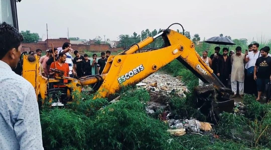 किरतपुर में नाले के पास बच्ची की तलाश करते नगरवासी और पुलिस।