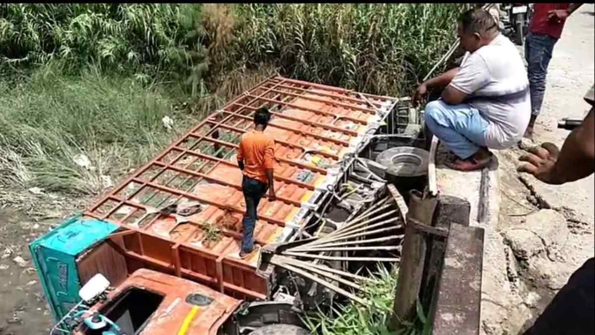 मालन नदी के जर्जर पुल पर टूटी रेलिंग के पास नदी में गिरा ट्रक, प्रशासनिक बचाव कार्य चल रहा है।